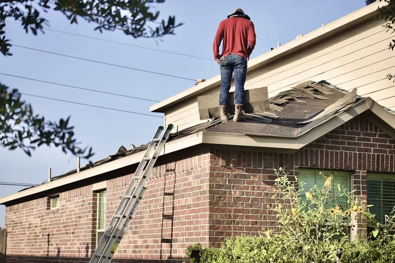 Professional roofer working on a residential roof in Newton Upper Falls